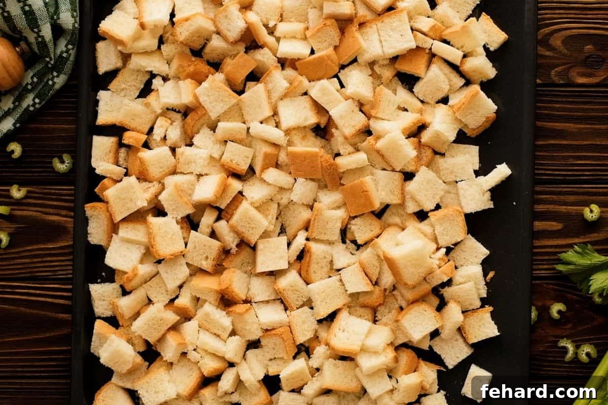 Homemade Stuffing Preparation Cubed bread spread out on a baking sheet, drying evenly for optimal stuffing texture.