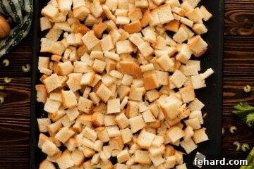 Cubed bread spread out on a baking dish to dry.