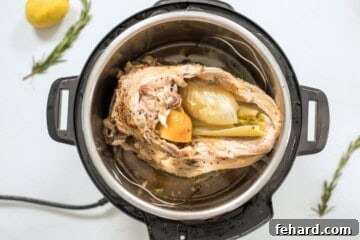 Instant Pot Turkey breast breast side down with celery and lemon inside cavity of turkey inside instant pot on trivet.