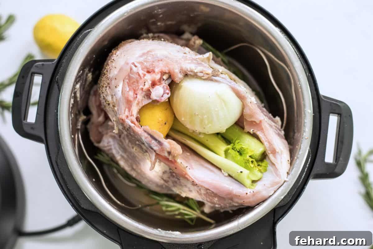 Raw turkey breast placed meat-side down on a trivet inside an Instant Pot, with celery, lemon, and rosemary tucked into the cavity.