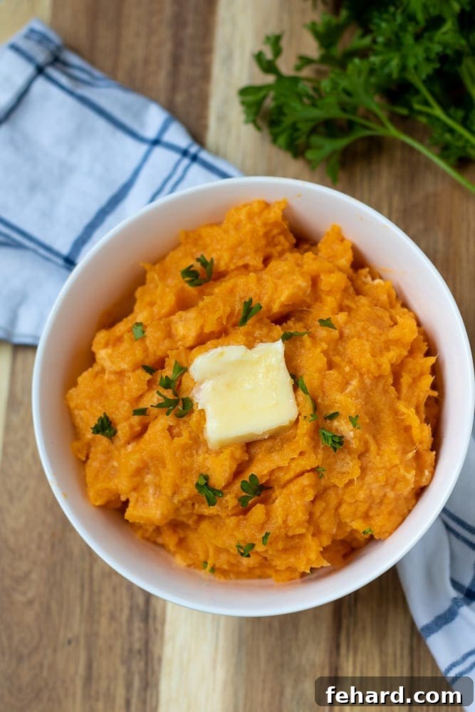 Mashed Sweet Potatoes A bowl of creamy mashed sweet potatoes, garnished with a pat of melted butter and fresh parsley.