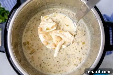 Ultimate Instant Pot White Chicken Chili 9 Ladle of white chicken chili coming out of the instant pot.