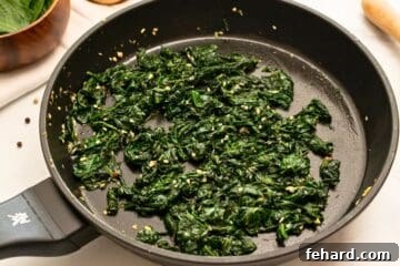Sauteed Spinach with garlic and lemon in skillet after wilting down.