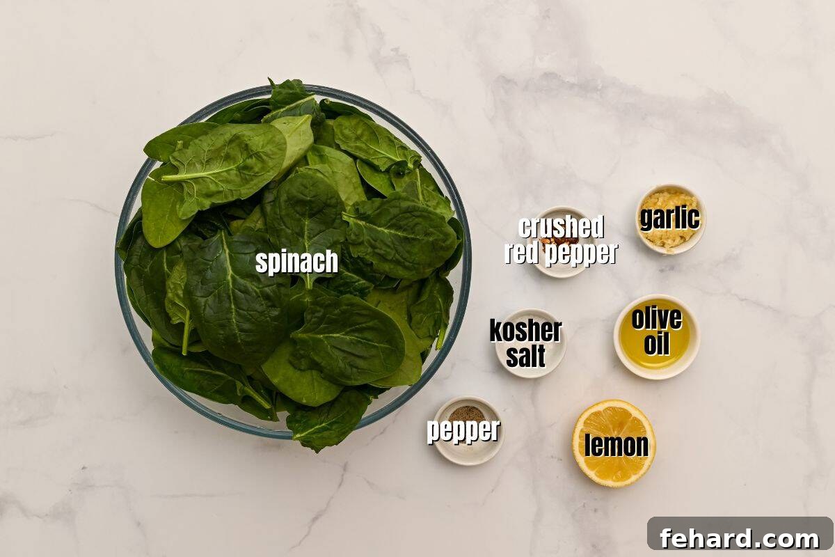 Spinach leaves, lemon, olive oil, garlic, salt, pepper, and red pepper flakes labeled on counter.