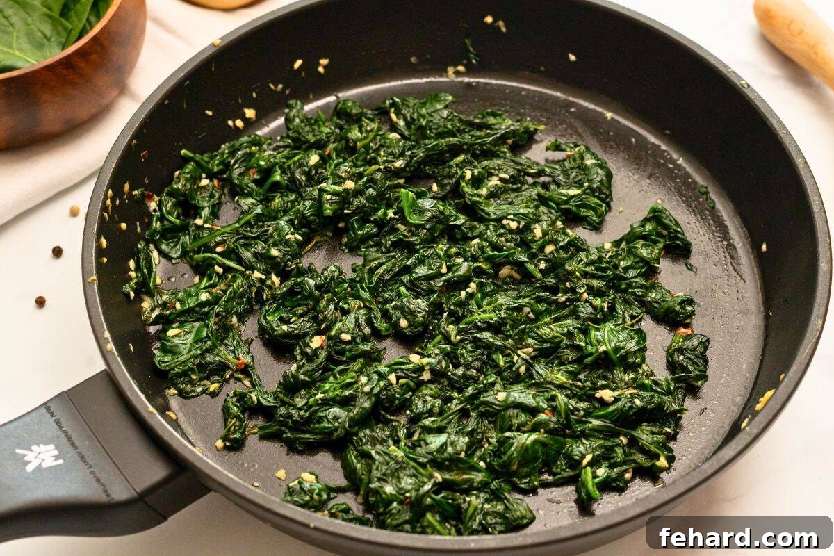 Sauteed Spinach with garlic and lemon in skillet after wilting down.