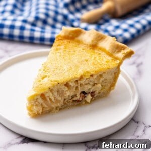 Slice of classic French Quiche Lorraine on white plate, highlighting its rich filling and flaky crust.