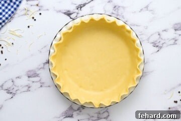 Pie crust shaped in pie pan before baking, with fluted edges.