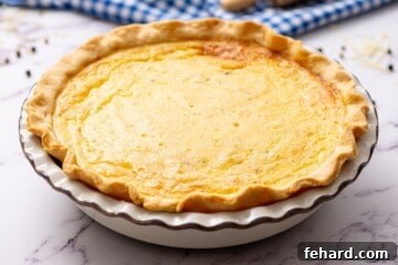 Baked Quiche Lorraine in white pie dish, golden and set.
