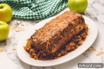 Hearty Slow Cooker Pork and Sauerkraut 7 Shredded pork loin on a white platter with sauerkraut, apples, and onions ready to be served.