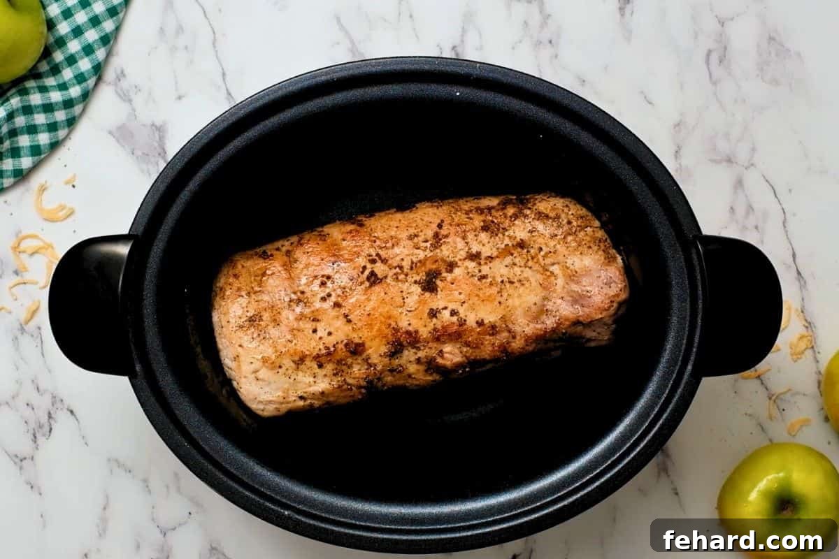 Seared Pork Loin for Sauerkraut Pork loin seasoned with salt and pepper being seared in a skillet, creating a golden crust.