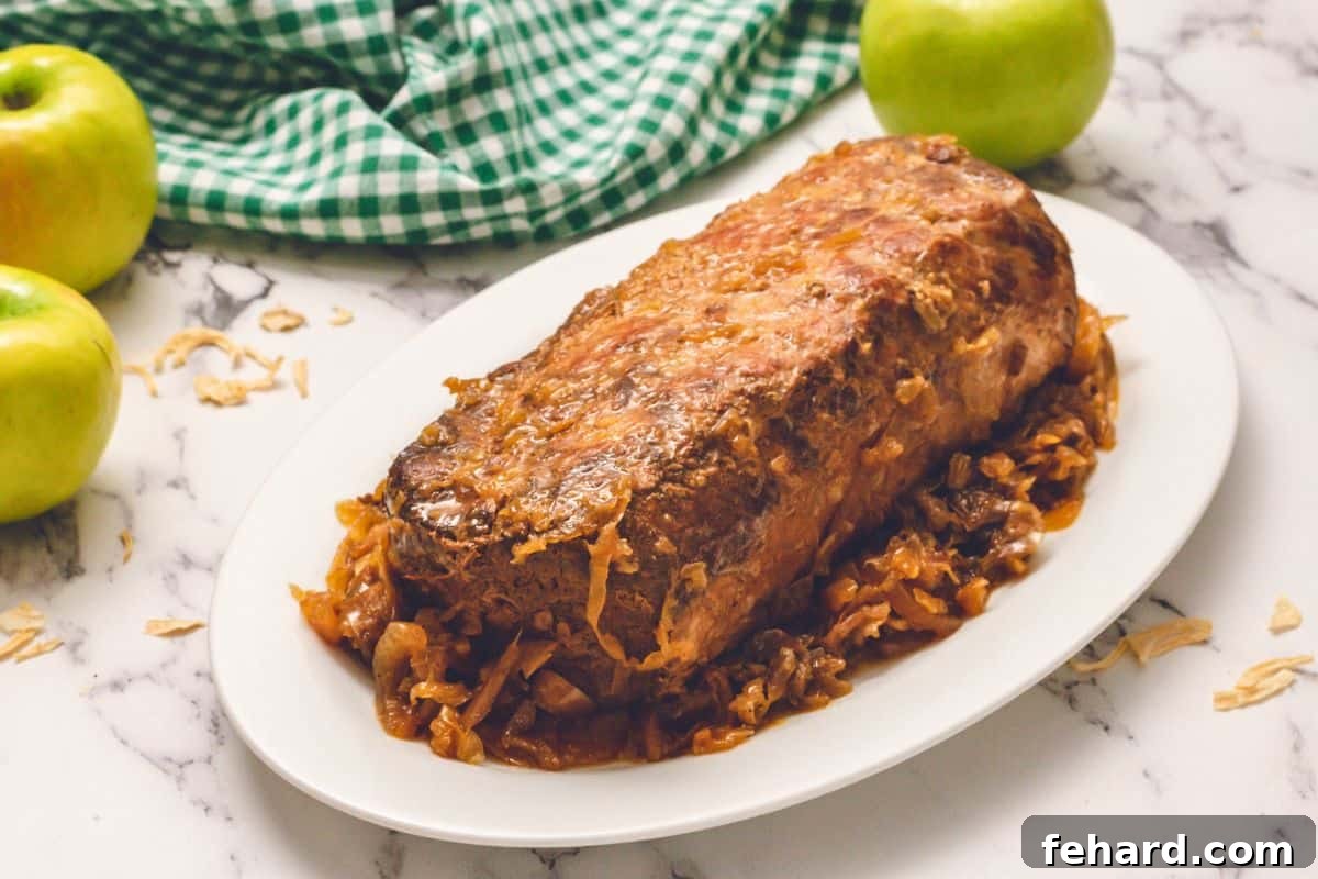Best Pork and Sauerkraut Shredded pork loin with sauerkraut, apples, and onions, served on a white platter ready to eat.