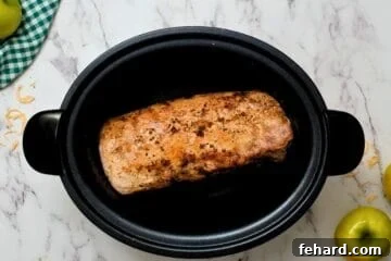 Hearty Slow Cooker Pork and Sauerkraut 4 Pork loin seasoned with salt and pepper being seared inside a large pan.