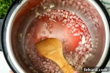 Fast & Flavorful Instant Pot Spaghetti 5 Wooden spoon scraping up browned bits on bottom of inner pot.