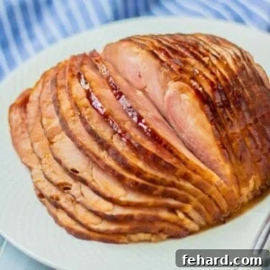 Instant Pot spiral sliced ham glazed in honey pineapple glaze on white platter next to electric pressure cooker.