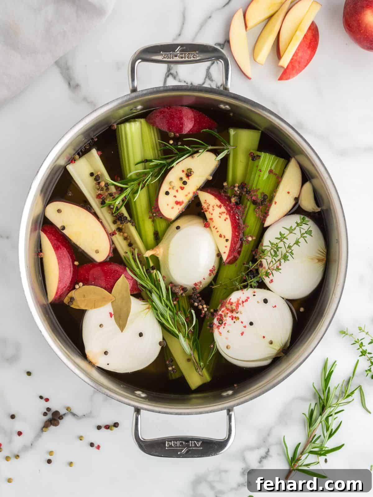 Ingredients for Turkey brine in stock pan with apples, onions, peppercorns, onions, and celery in stock pan.