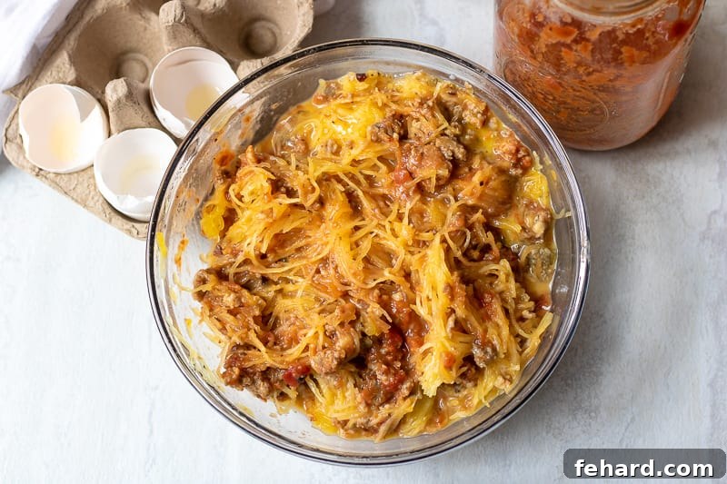 Spaghetti Squash Bake Preparation Spaghetti Squash Casserole Mixture in glass bowl, ready for baking.