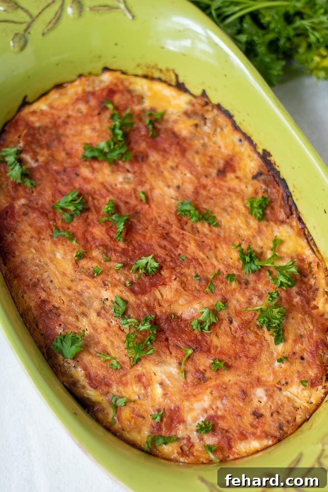 Finished Spaghetti Squash Casserole Paleo Spaghetti Squash Casserole in a vibrant green baking dish, garnished and ready to serve.