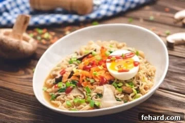 Bowl of homemade ramen topped with soft boiled egg, green onions, and sriracha.