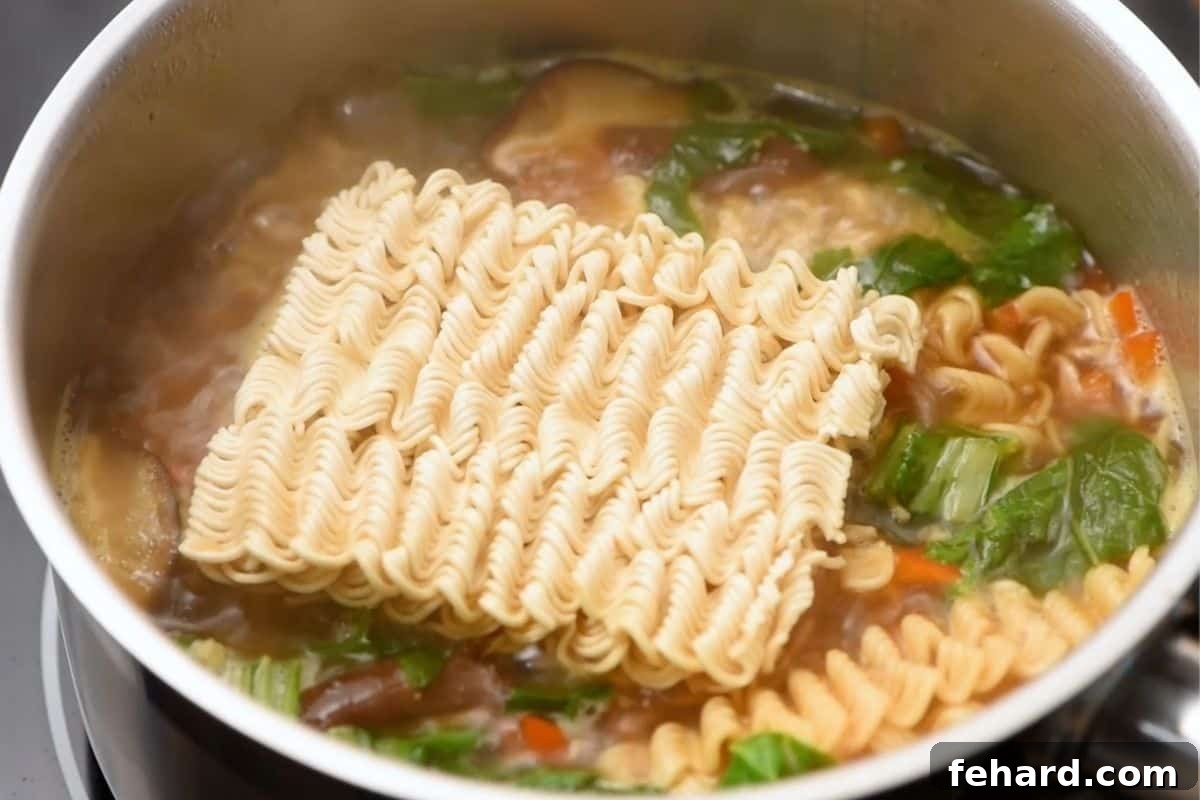 Best Ramen Recipe Ramen noodles cooking gently in the rich broth with vegetables, absorbing all the wonderful flavors.