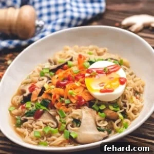 Bowl of homemade ramen topped with soft boiled egg, green onions, and sriracha.