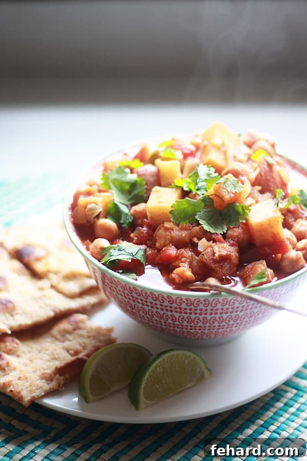 Slow Cooker Indian Spiced Chickpeas and Potatoes served in a bowl, garnished with fresh cilantro.