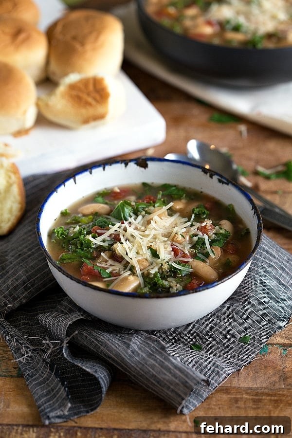 slow cooker quinoa white bean and kale soup in a bowl, garnished with a sprinkle of red pepper flakes.
