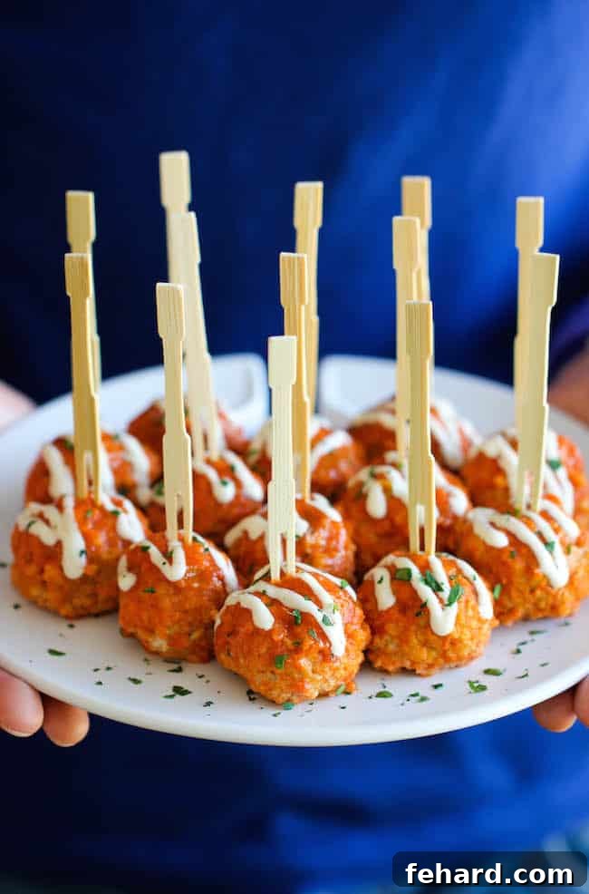 slow cooker buffalo chicken meatball served with blue cheese dressing and celery sticks.