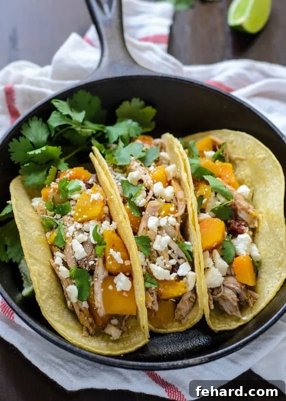 Slow Cooker Butternut Squash and Pulled Pork Tacos, garnished with fresh cilantro and a squeeze of lime.