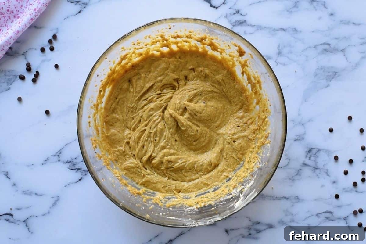 Creamed Cookie Ingredients Creamed eggs, butter, and sugar in a large mixing bowl, demonstrating the pale and fluffy consistency.