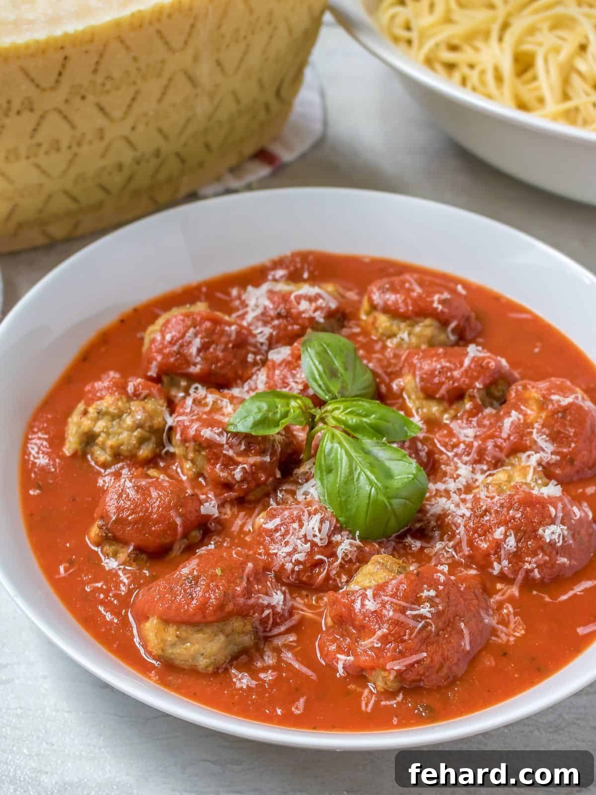 Instant Pot Meatballs Instant Pot Meatballs in white bowl served with marinara and topped with fresh parmesan and basil.