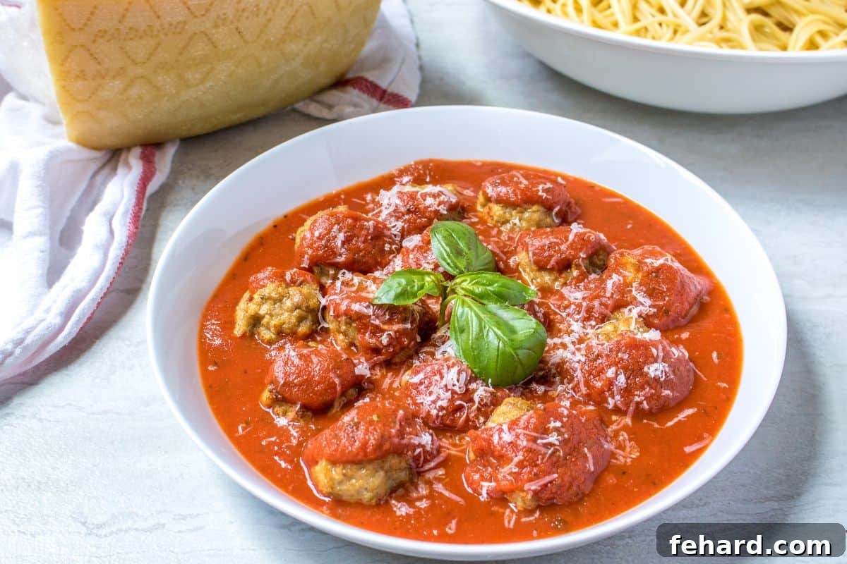Pressure Cooker Meatballs Instant Pot Meatballs in white bowl served with marinara and topped with fresh parmesan and basil.