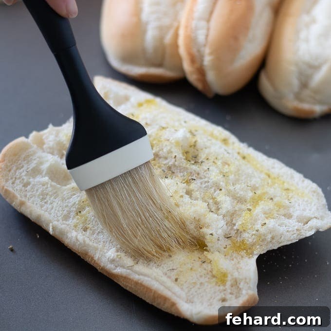 How to make the best meatball sub: Toasting the bun with garlic oil Pastry Brush Brushing Seasoned Olive Oil on Hoagie Bun for flavor infusion.