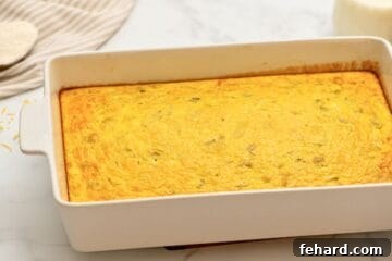 Baked egg casserole in white casserole dish made with cottage cheese and green chiles.