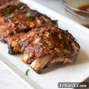Instant Pot Ribs on platter topped with BBQ sauce.