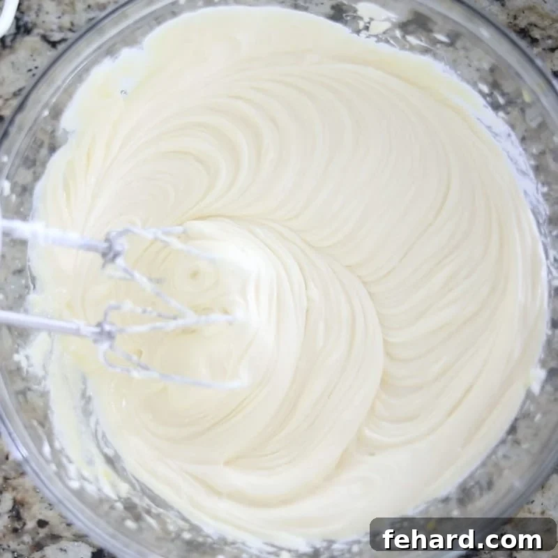 Cheesecake with egg whites batter Rich, creamy cheesecake batter in a clear mixing bowl, showcasing its smooth texture before baking.