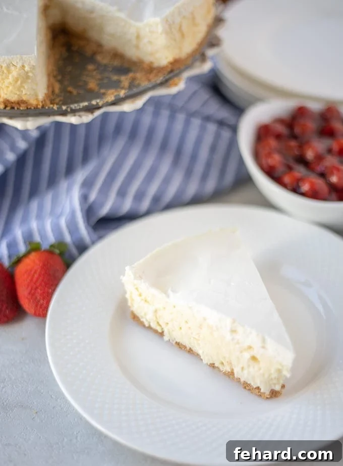 Cheesecake Recipe with Sour Cream and Strawberries A beautifully presented slice of classic cheesecake on a white plate, garnished with fresh strawberries, ready to be enjoyed.
