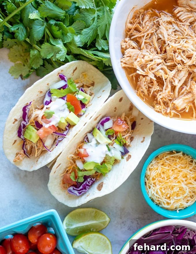 Delicious Instant Pot Chicken Tacos made with perfectly seasoned shredded chicken, topped with fresh lettuce, cheese, and a squeeze of lime.