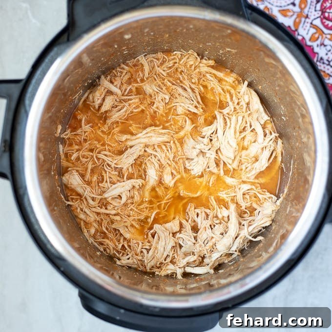 Instant Pot filled with freshly shredded chicken taco meat, moist and perfectly seasoned.