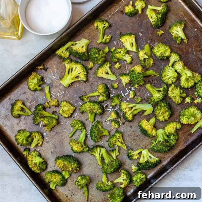 Perfectly roasted broccoli with crispy edges on a sheet pan, just out of the oven.