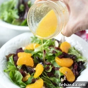 Fresh orange dressing being poured over mandarin orange salad.