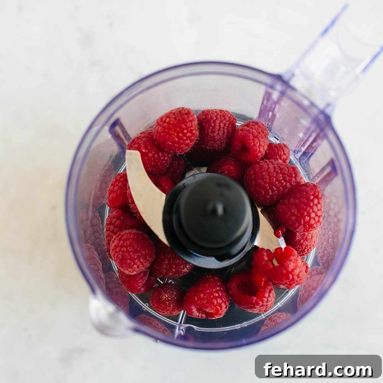 Dreamy Raspberry Chia Pudding 5 Photo showing fresh raspberries in a food processor, ready to be pureed.