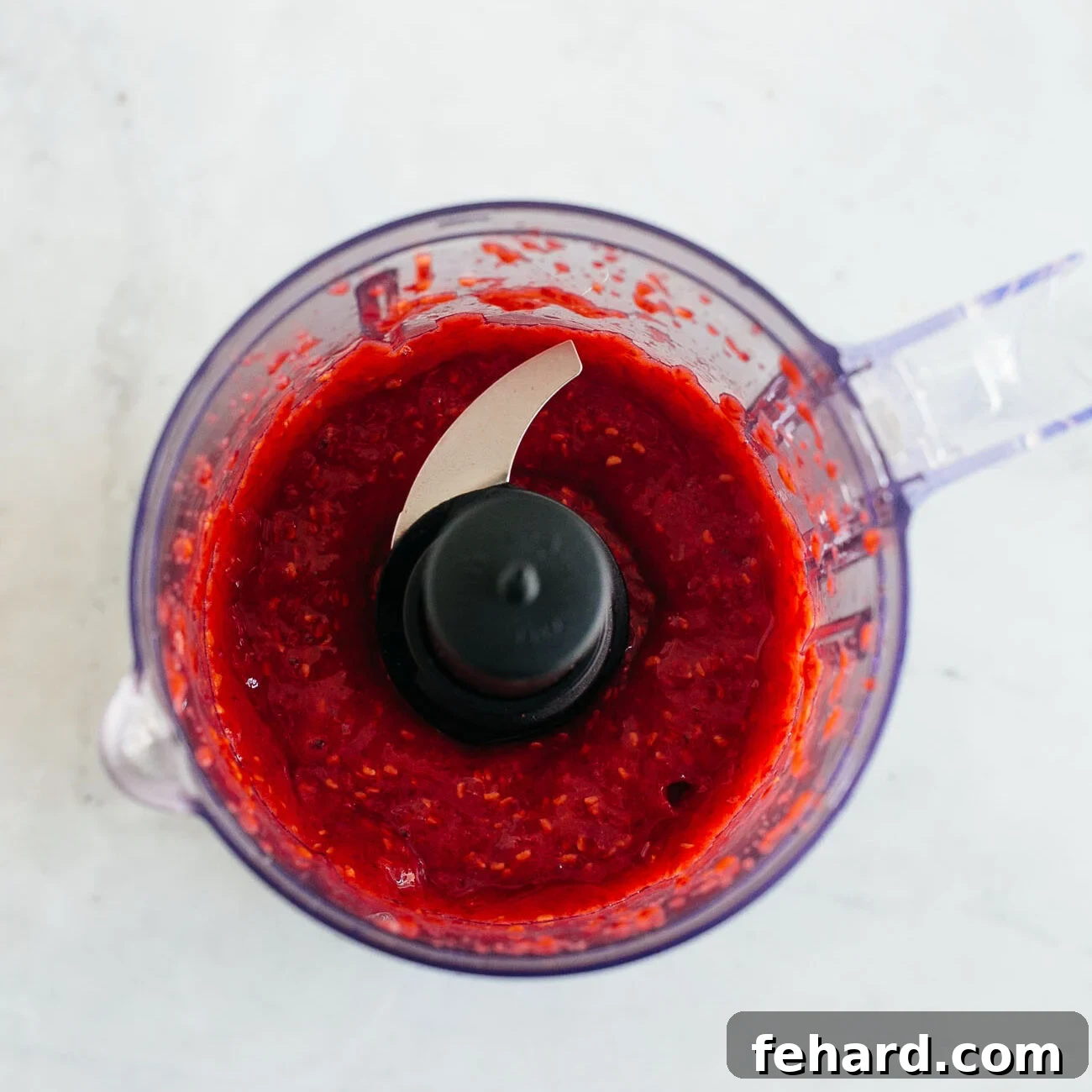 Dreamy Raspberry Chia Pudding 6 Photo showing pureed raspberries in a food processor, a smooth and brightly colored mixture.