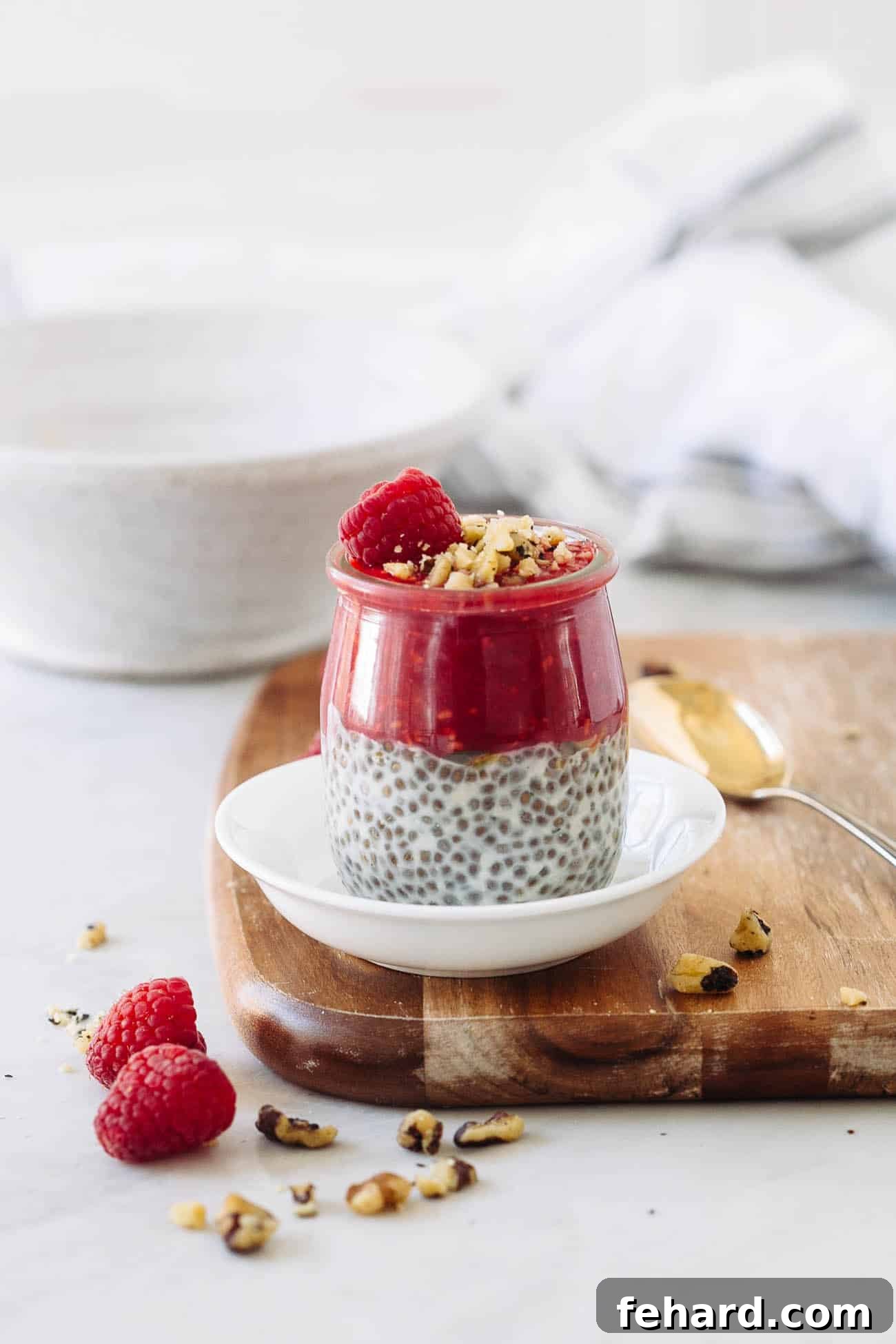 Dreamy Raspberry Chia Pudding 7 A beautiful jar of raspberry chia seed pudding, layered with raspberry puree, topped with fresh raspberries, and sprinkled with pistachios.
