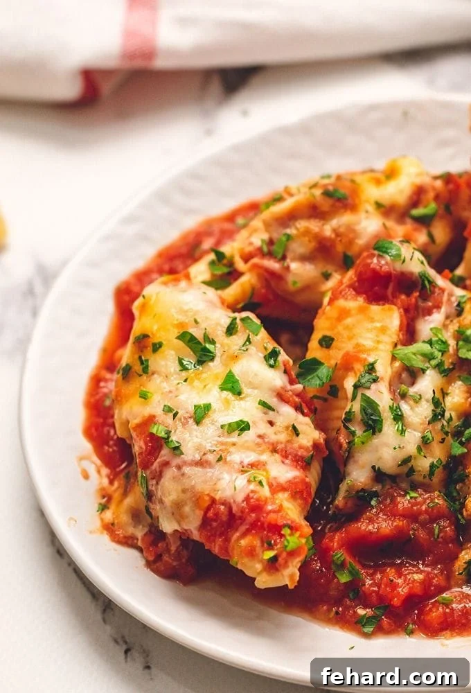 Classic Stuffed Shells Recipe Cheesy Stuffed Shells On white plate garnished with fresh herbs
