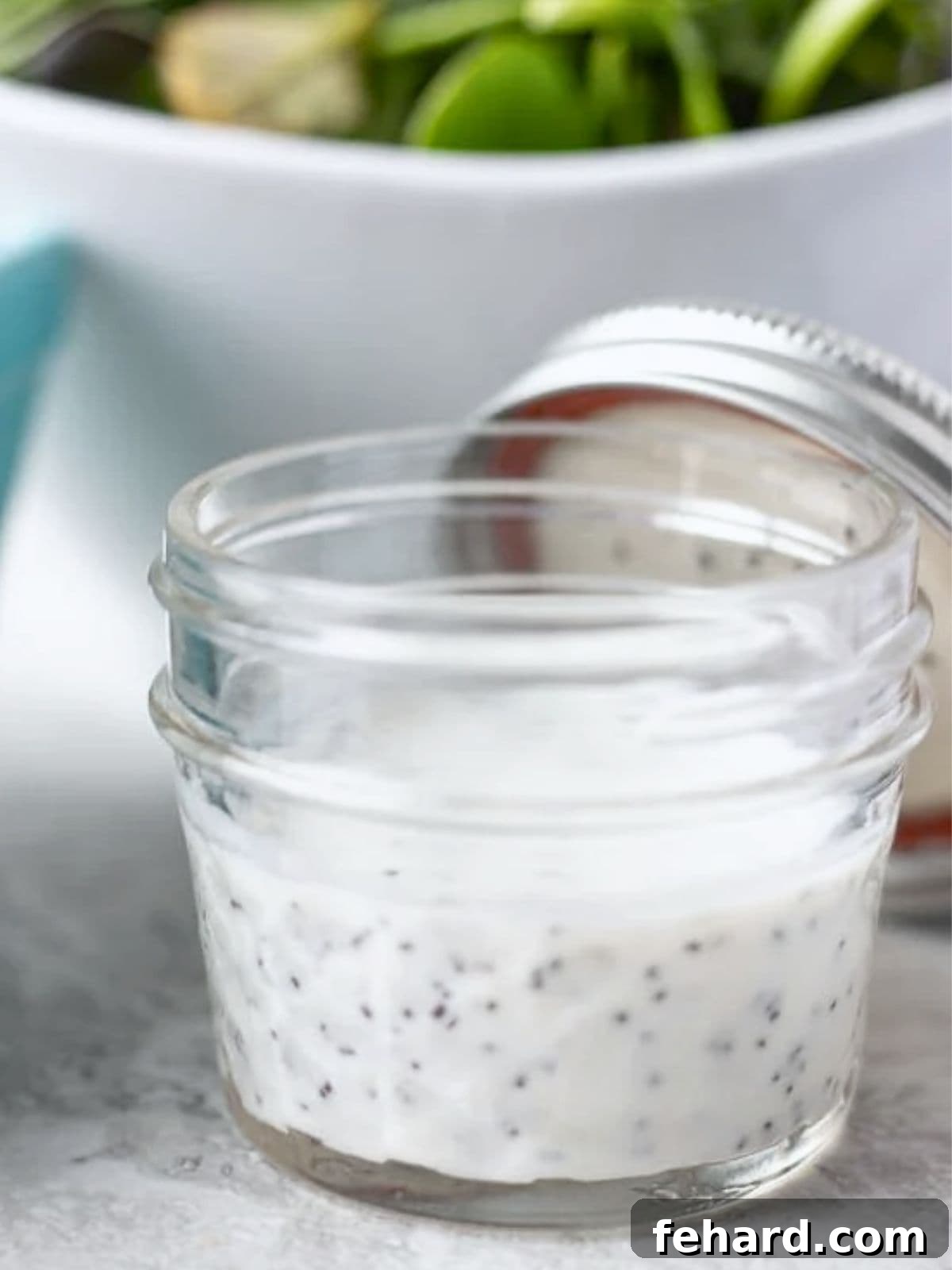 Easy Poppy Seed Dressing in a Jar Poppy seed dressing with Greek yogurt stored in a small glass jar, ready for chilling.