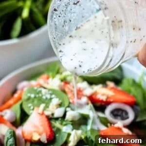 Creamy poppy seed yogurt made with greek yogurt being poured over strawberry salad dressing.