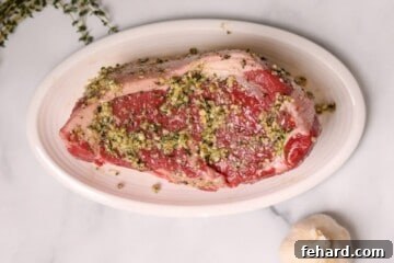 Seasoned New York Strip Roast on white platter.
