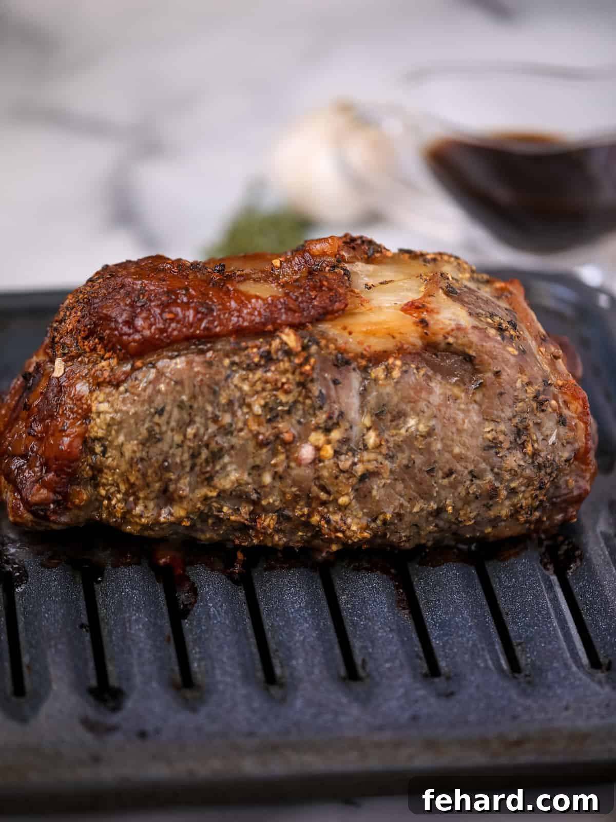 A perfectly roasted New York Strip on a broiler pan, displaying a rich, browned crust.