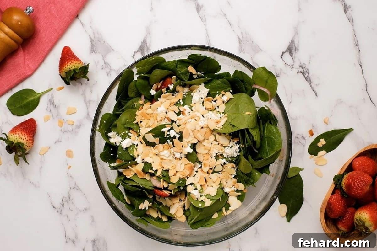Feta and almonds sprinkled over spinach strawberry salad.