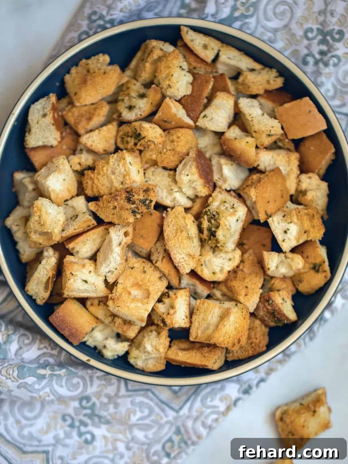 A rustic bowl overflowing with freshly baked, golden-brown homemade croutons, perfectly seasoned and ready to serve.